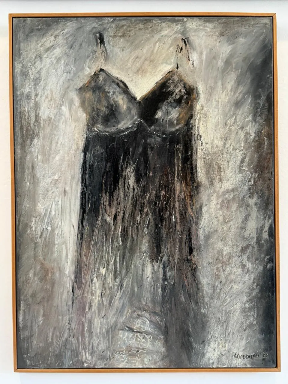 A dark slip-dress emerging from a grey, atmospheric ground - quiet and tonal.